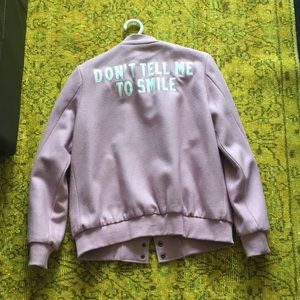 Pink “don’t tell me to smile” bomber jacket